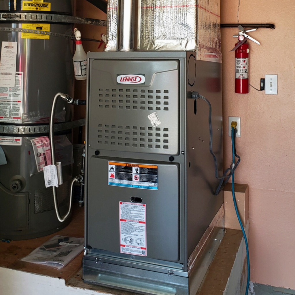 Lennox indoor gas furnace installed in a garage next to a water heater