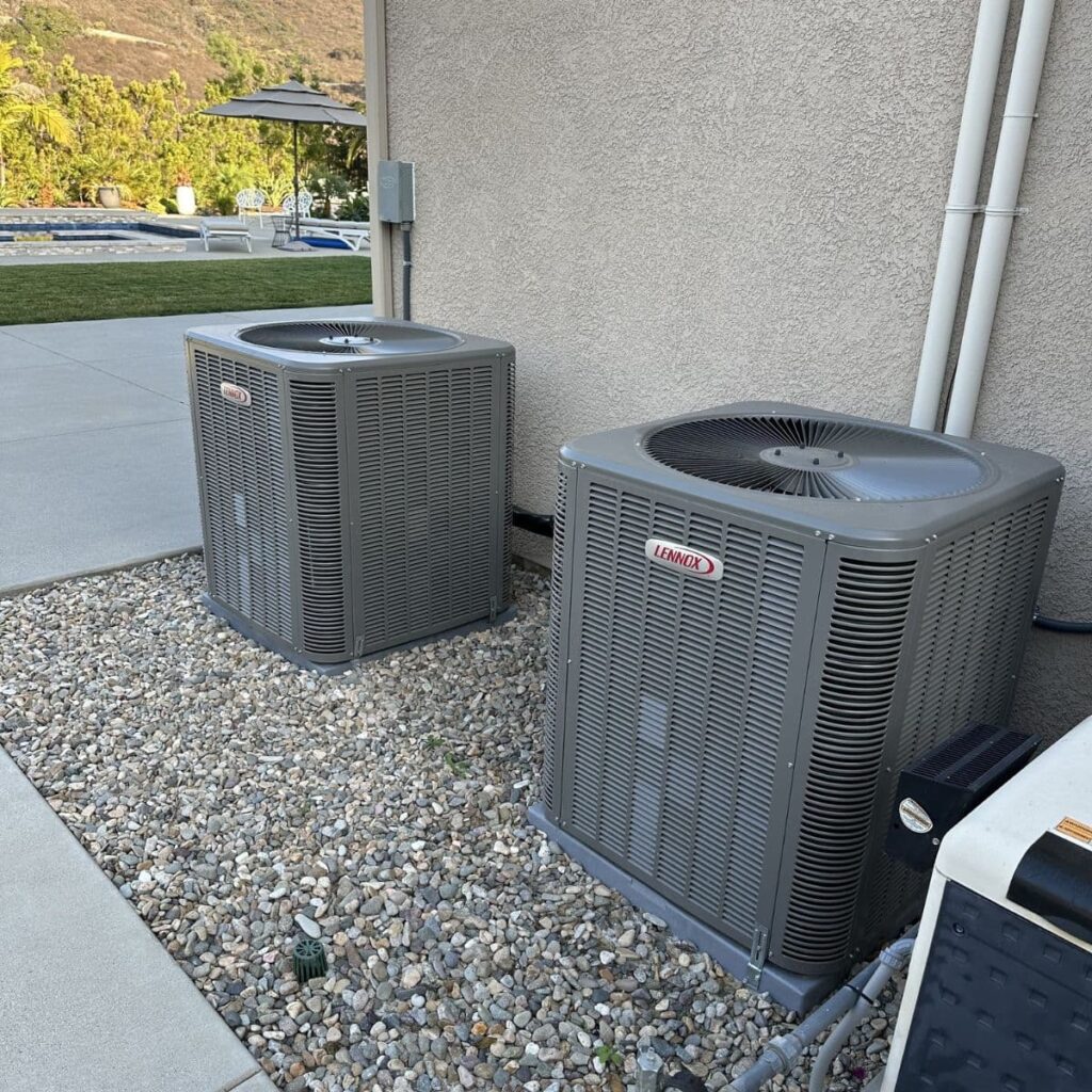 Dual Lennox air conditioning units installed on gravel beside a residential home