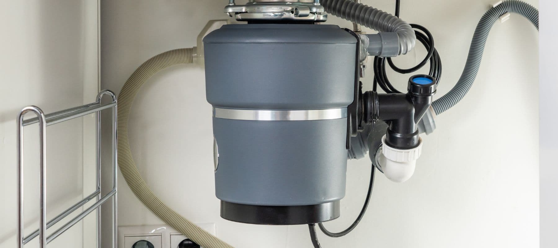 Close-up of a garbage disposal unit installed beneath a kitchen sink