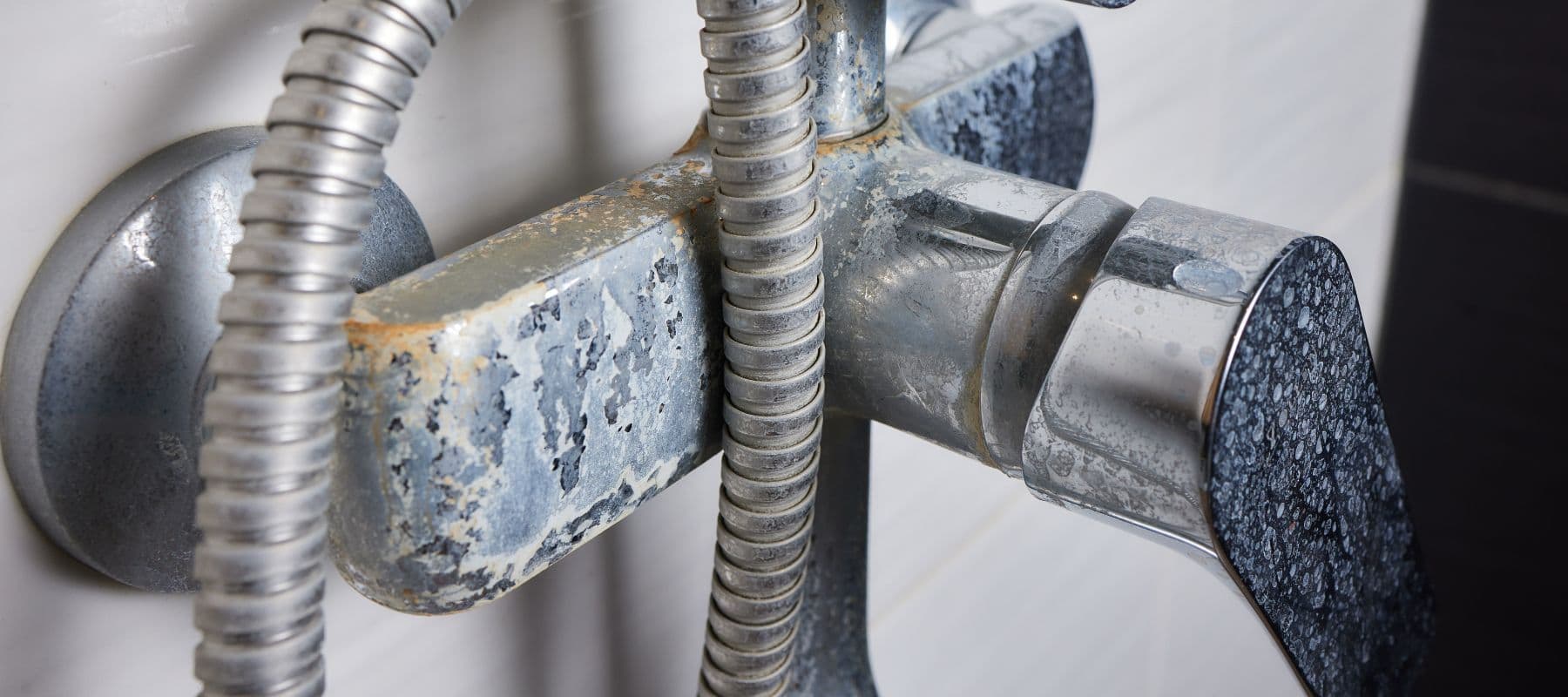 shower fixture with heavy white mineral buildup and corrosion